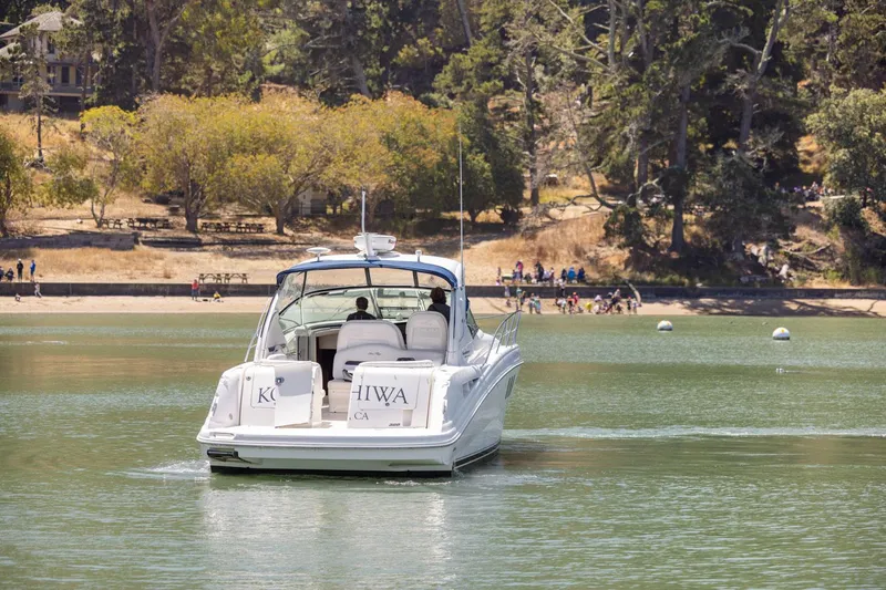 Konichiwa Yacht Photos Pics Sea Ray 390 Sundancer 2010 cruising on a serene lake with forested shoreline.