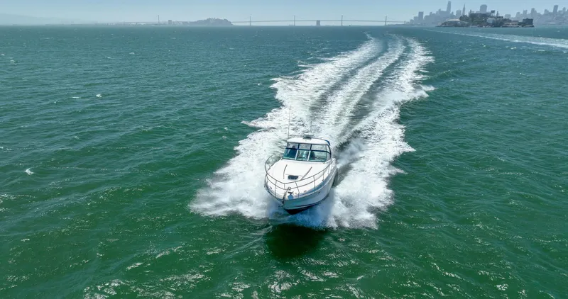 Konichiwa Yacht Photos Pics Sea Ray 390 Sundancer 2010 cruising on open water with city skyline in background.