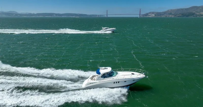 Konichiwa Yacht Photos Pics 2010 Sea Ray 390 Sundancer cruising on open water with bridge in background.
