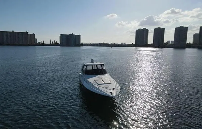  Yacht Photos Pics 2009 Cruisers Yachts 460 Express on water with city skyline backdrop.
