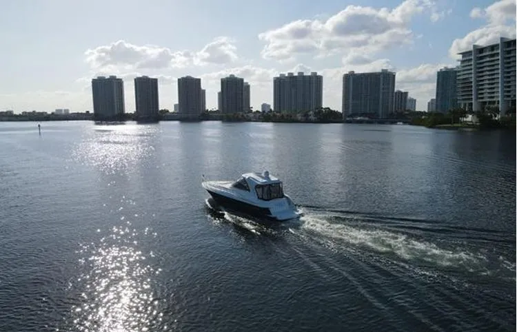  Yacht Photos Pics 2009 Cruisers Yachts 460 Express cruising on a sunlit urban waterway.