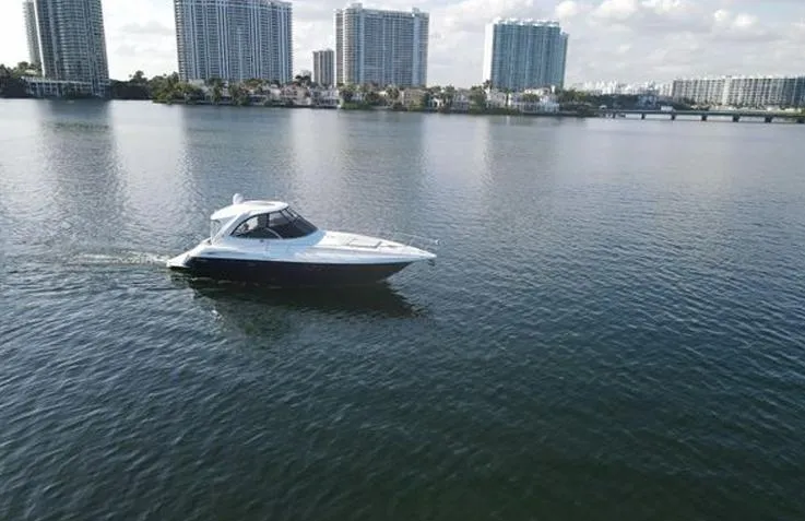  Yacht Photos Pics 2009 Cruisers Yachts 460 Express on calm water with city skyline backdrop.