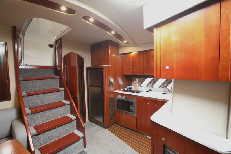  Yacht Photos Pics 2009 Cruisers Yachts 460 Express interior with wooden cabinetry and modern kitchen amenities.