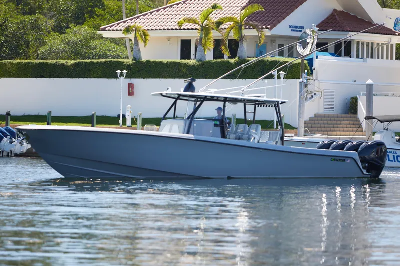  Yacht Photos Pics 2022 Contender 44 ST boat docked near a waterfront home.