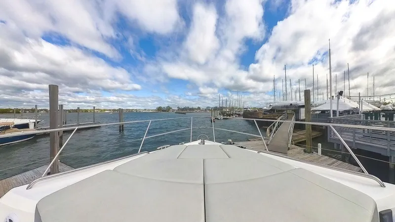 Above Deck Yacht Photos Pics Bow view of 2018 Princess S60 yacht docked at a marina under a partly cloudy sky.