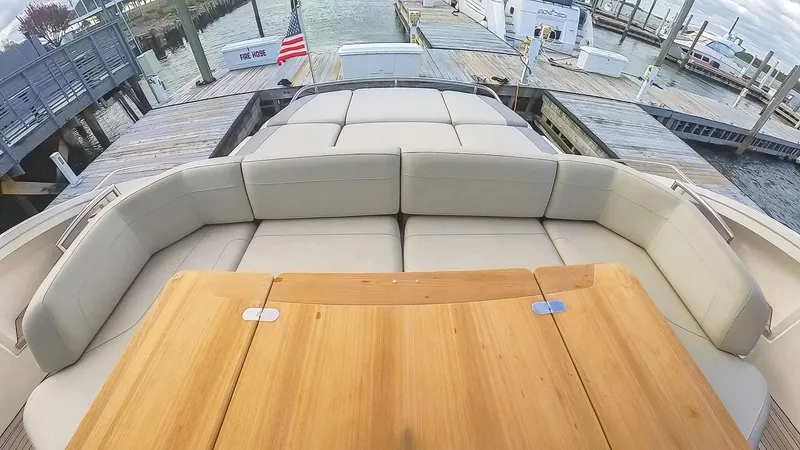 Above Deck Yacht Photos Pics Luxurious seating area on a 2018 Princess S60 yacht, docked at a marina.