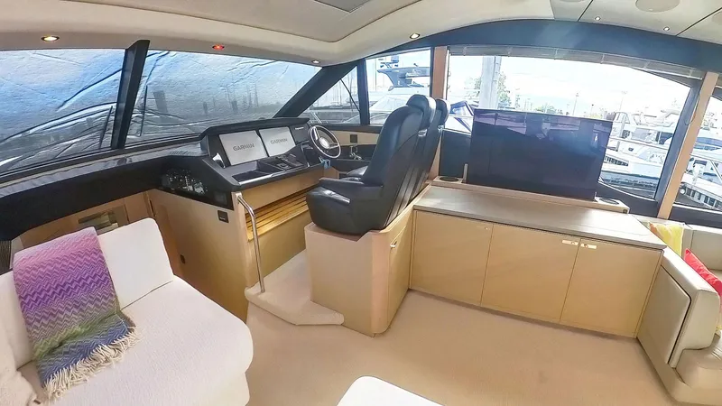 Above Deck Yacht Photos Pics Luxurious interior of a 2018 Princess S60 yacht with modern helm and seating area.