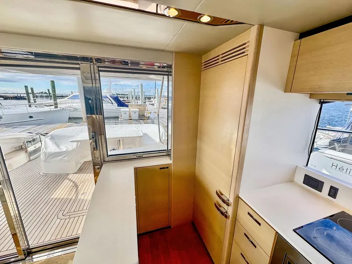 Above Deck Yacht Photos Pics Interior view of 2018 Princess S60 yacht kitchen with modern design and marina backdrop.
