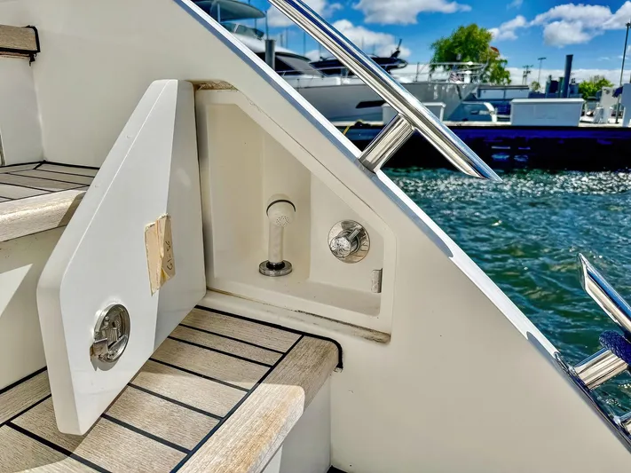 Above Deck Yacht Photos Pics 2018 Princess S60 yacht stairs with open storage compartment by the water.