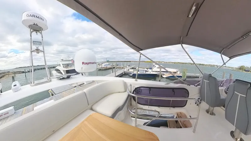Above Deck Yacht Photos Pics 2018 Princess S60 yacht deck with seating, docked at marina under cloudy sky.