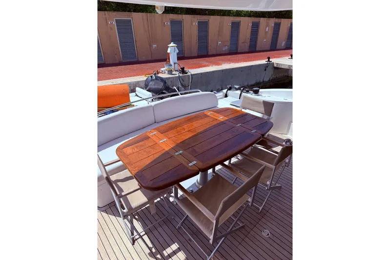  Yacht Photos Pics Outdoor dining area on a 2007 Sunseeker Manhattan 66 yacht with wooden table and chairs.