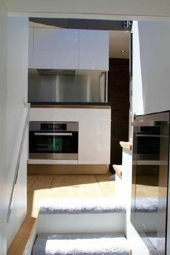  Yacht Photos Pics Modern kitchen interior on Absolute 70 yacht, 2012 model, featuring sleek white cabinetry and stainless steel appliances.