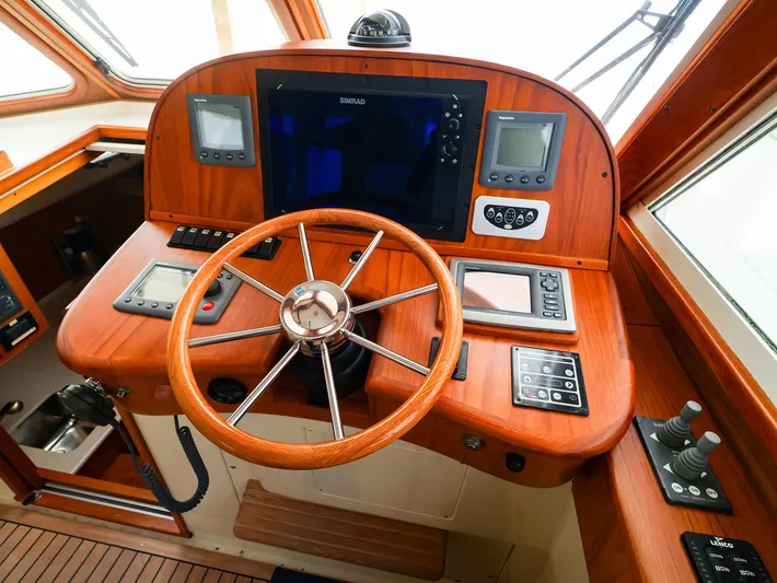 4814ak Yacht Photos Pics Helm of 2009 Legacy 32 boat with wooden dashboard and modern navigation equipment.