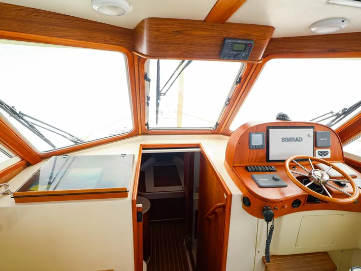 4814ak Yacht Photos Pics Pilothouse interior of 2009 Legacy 32 boat with wooden dashboard and navigation equipment.