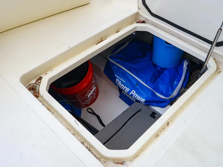 4814ak Yacht Photos Pics Open storage compartment on 2009 Legacy 32 boat with various items inside.