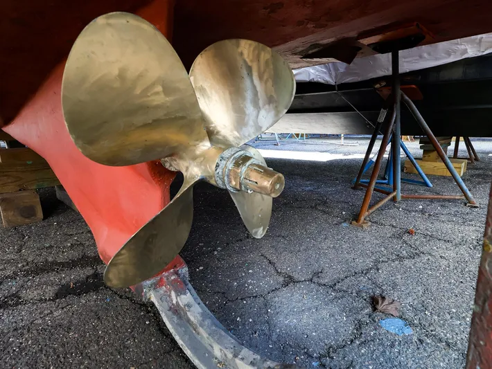 4814ak Yacht Photos Pics Propeller of 2009 Legacy 32 boat on dry dock, showing metal blades and rudder.