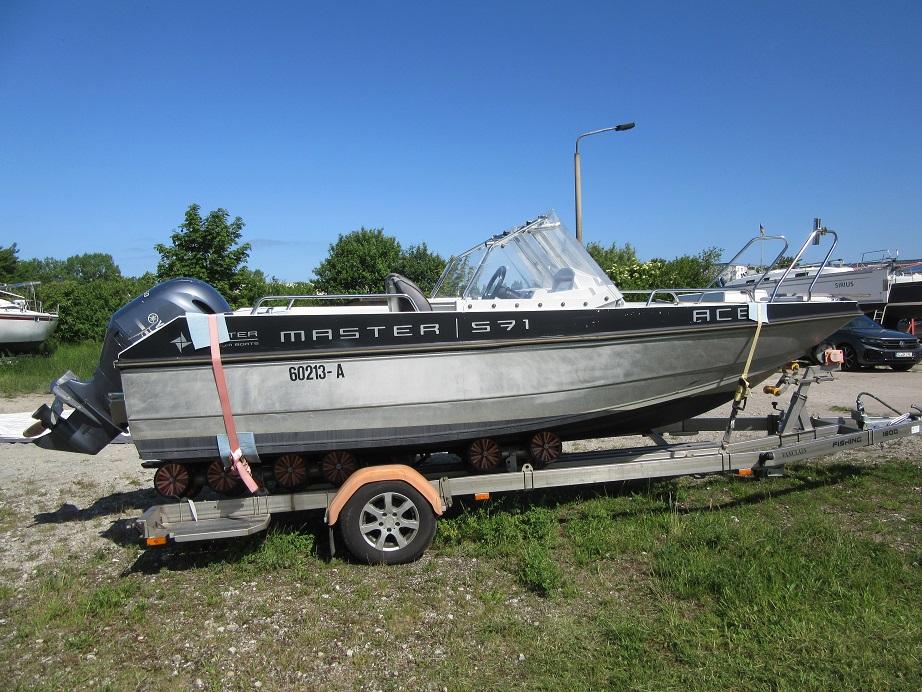 Boat on trailer, Master Pro 571, 2016 model, parked outdoors on a sunny day.