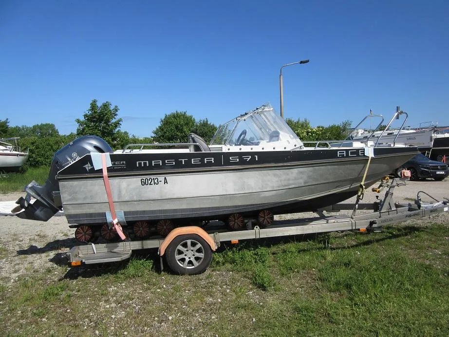 Boat on trailer, Master Pro 571, 2016 model, parked outdoors on a sunny day.