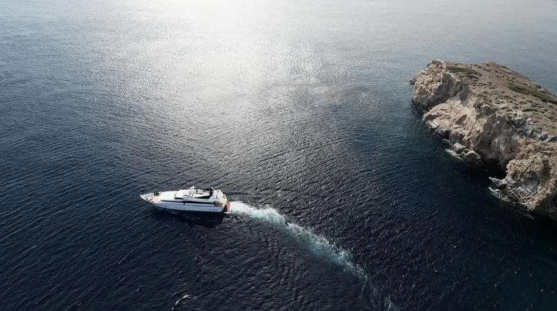 Bellini Yacht Photos Pics Aerial view of 1988 Cantieri di Pisa AKHIR 30 yacht near rocky coastline.