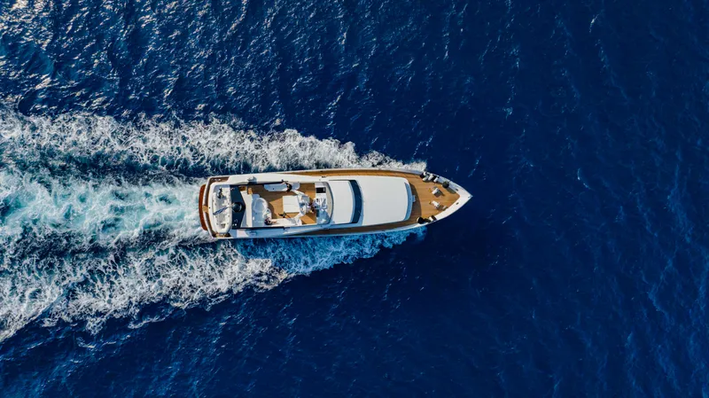 Bellini Yacht Photos Pics Aerial view of 1988 Cantieri di Pisa AKHIR 30 yacht cruising on open blue sea.