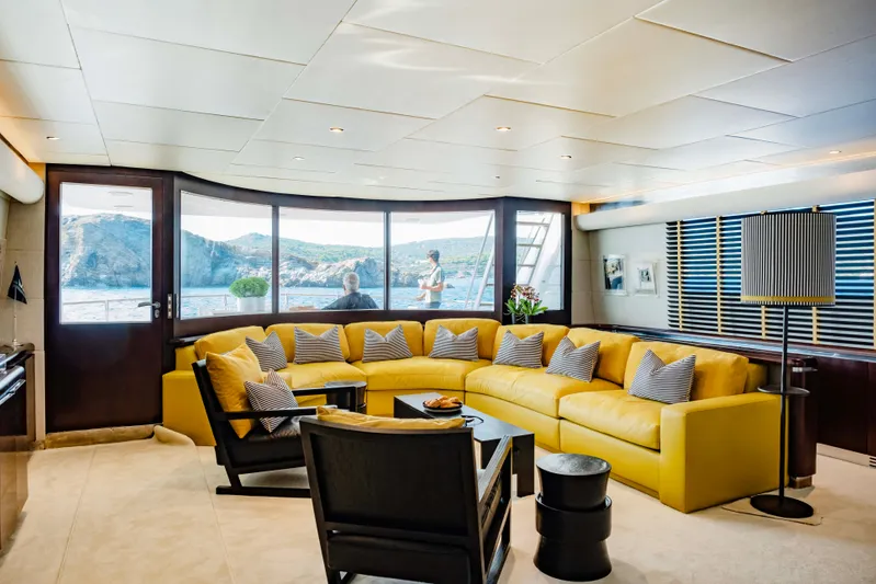Bellini Yacht Photos Pics Luxurious 1988 Cantieri di Pisa AKHIR 30 yacht interior with yellow seating and scenic window views.