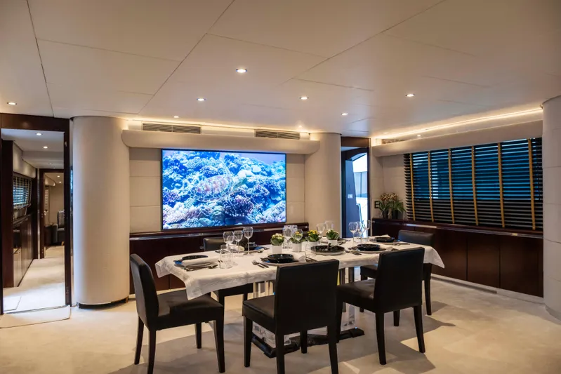 Bellini Yacht Photos Pics Luxurious dining area on 1988 Cantieri di Pisa AKHIR 30 yacht, featuring elegant decor and large screen.