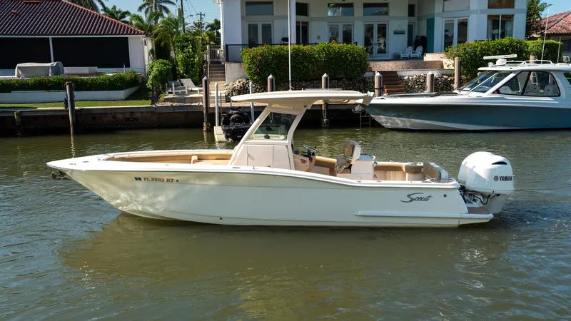  Yacht Photos Pics 2019 Scout 275 LXF boat docked on calm water near waterfront homes.