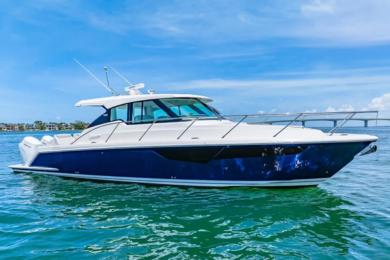  Yacht Photos Pics 2022 Tiara Yachts 43 LE cruising on clear blue water under a sunny sky.