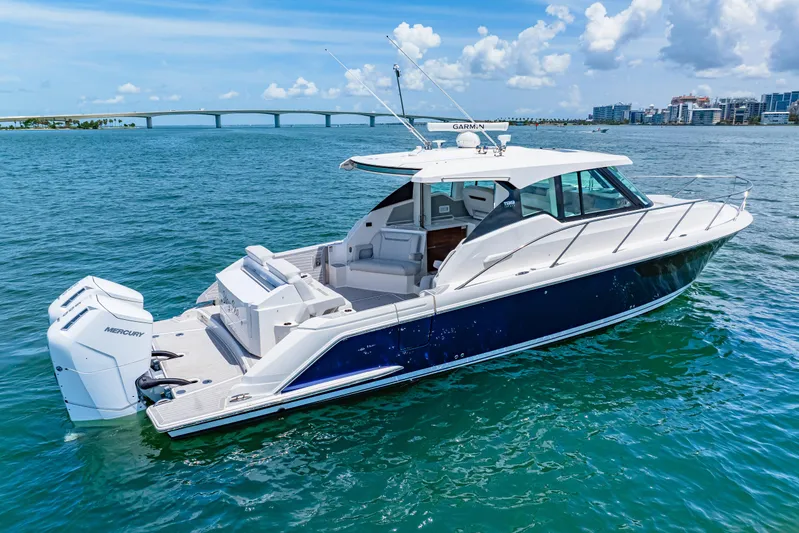  Yacht Photos Pics 2022 Tiara Yachts 43 LE cruising on blue waters near a bridge.