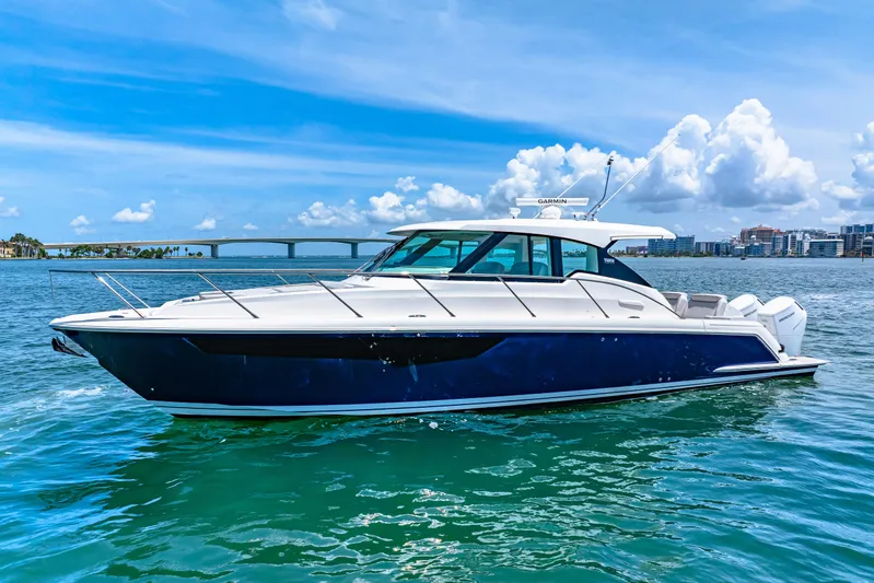  Yacht Photos Pics 2022 Tiara Yachts 43 LE cruising on a sunny day with a bridge in the background.
