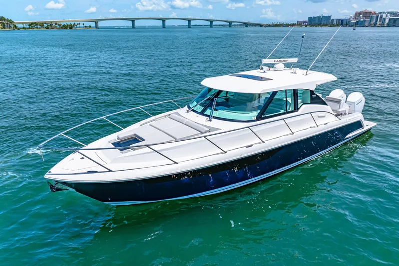  Yacht Photos Pics 2022 Tiara Yachts 43 LE cruising on blue waters with a scenic bridge backdrop.