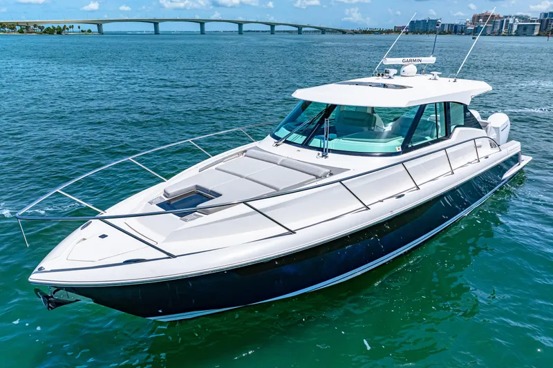  Yacht Photos Pics 2022 Tiara Yachts 43 LE cruising on clear blue water near a bridge.