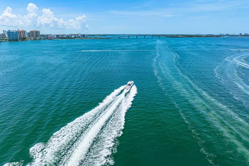  Yacht Photos Pics 2022 Tiara Yachts 43 LE cruising on blue ocean near city skyline.