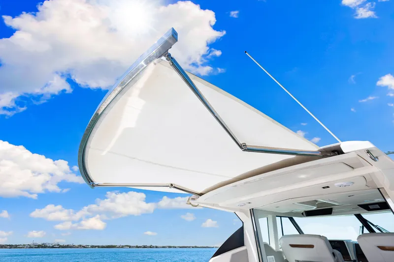  Yacht Photos Pics 2022 Tiara Yachts 43 LE with open canopy against blue sky and ocean backdrop.