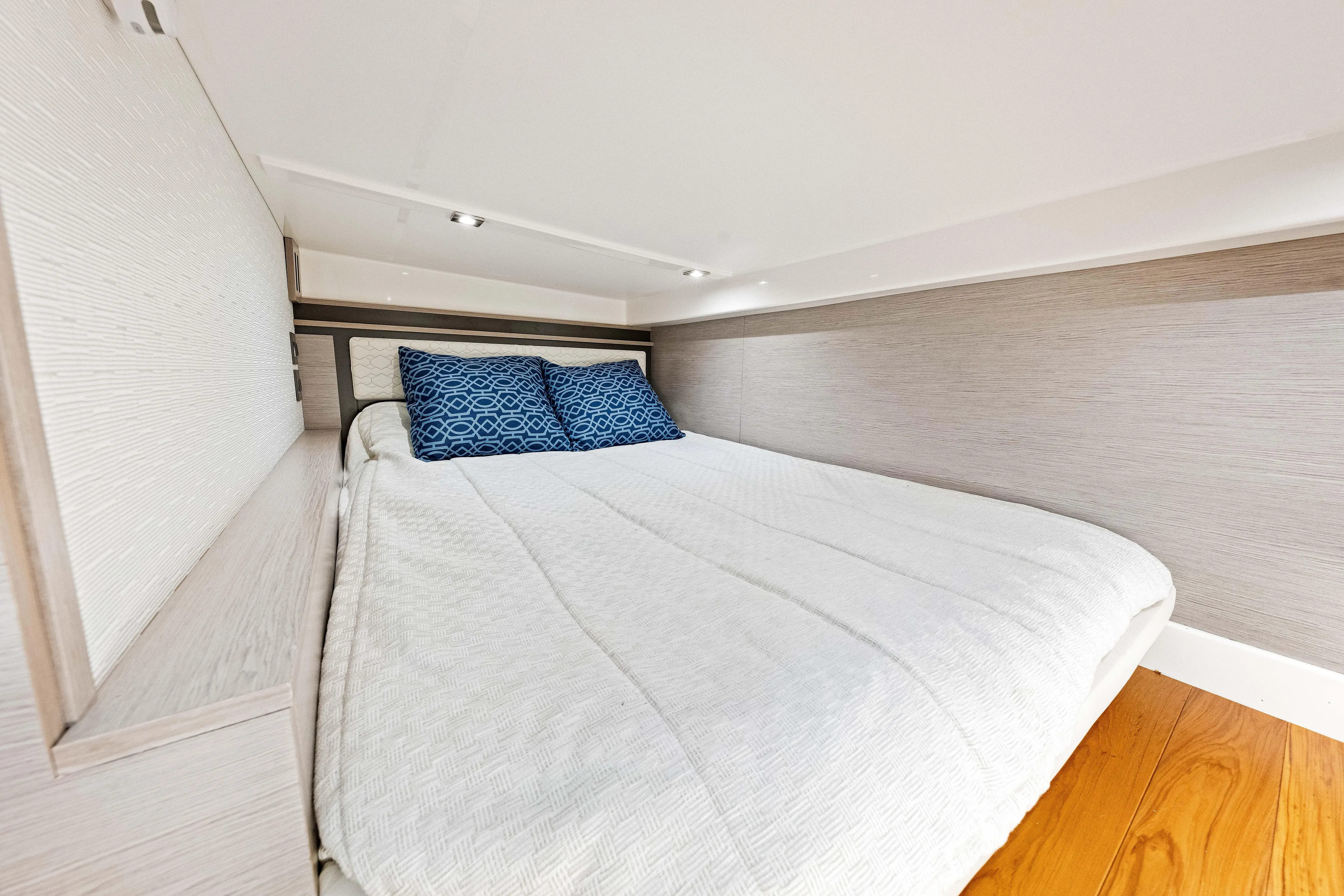  Yacht Photos Pics Cozy cabin interior of 2022 Tiara Yachts 43 LE with elegant bedding and wood accents.