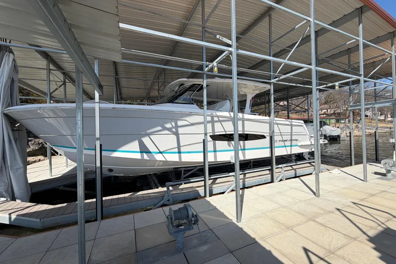  Yacht Photos Pics 2023 Regal 38 SAV boat docked under a metal canopy.