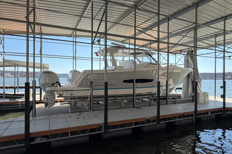  Yacht Photos Pics 2023 Regal 38 SAV boat docked under a covered marina on a sunny day.