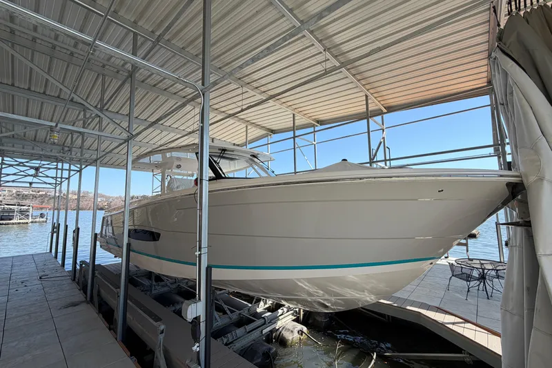  Yacht Photos Pics 2023 Regal 38 SAV boat docked under a covered marina on a sunny day.