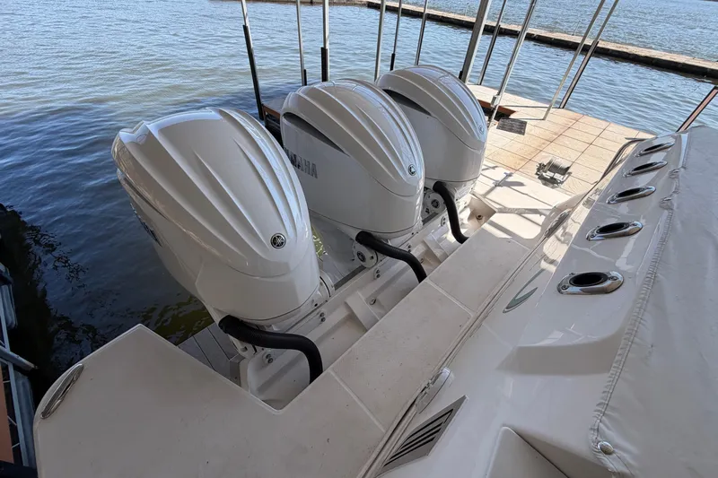  Yacht Photos Pics 2023 Regal 38 SAV boat with triple Yamaha outboard engines docked by the water.