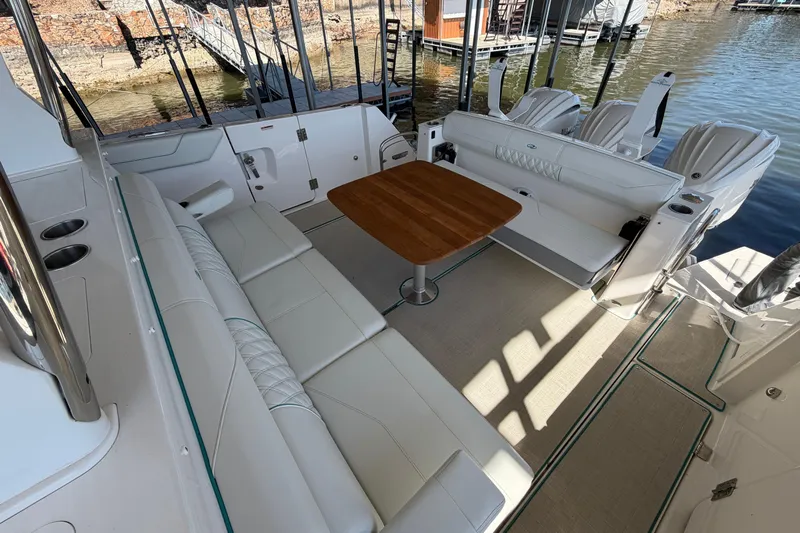  Yacht Photos Pics Luxurious seating area on 2023 Regal 38 SAV boat with wooden table and water view.