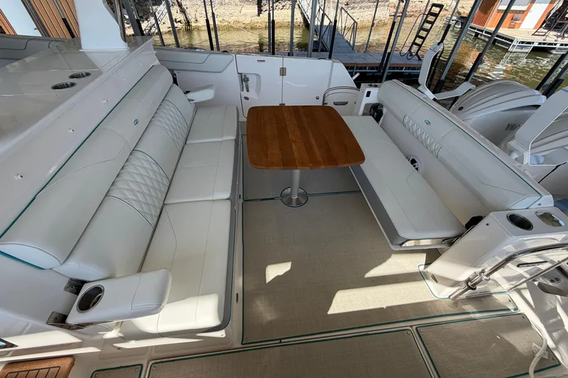  Yacht Photos Pics Luxurious seating area on 2023 Regal 38 SAV boat with wooden table and white upholstery.