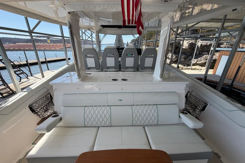  Yacht Photos Pics 2023 Regal 38 SAV boat interior with seating and helm, docked by the water.