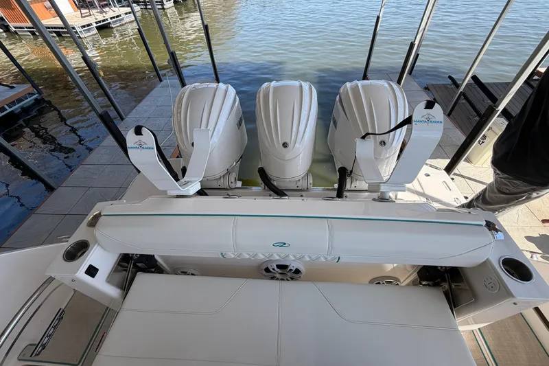  Yacht Photos Pics 2023 Regal 38 SAV boat with triple outboard engines docked by the water.
