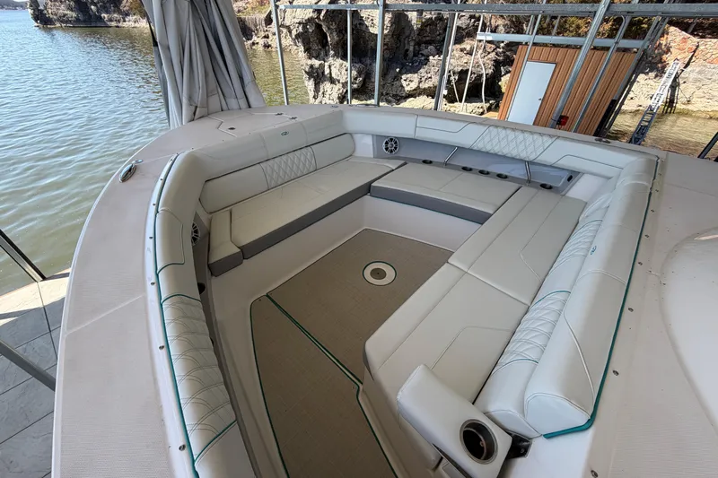  Yacht Photos Pics Luxurious seating area on a 2023 Regal 38 SAV boat, docked by rocky shoreline.