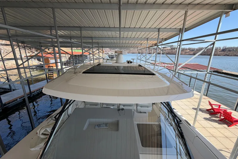  Yacht Photos Pics 2023 Regal 38 SAV yacht docked under a covered marina with scenic lake view.