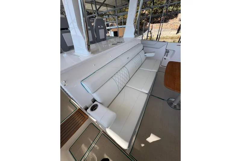  Yacht Photos Pics 2023 Regal 38 SAV boat interior with white seating and wooden table.