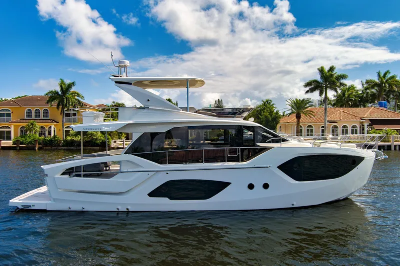 Joan's Rondevous Yacht Photos Pics 2025 Absolute 52 FLY yacht on a sunny waterfront with palm trees and luxury homes.