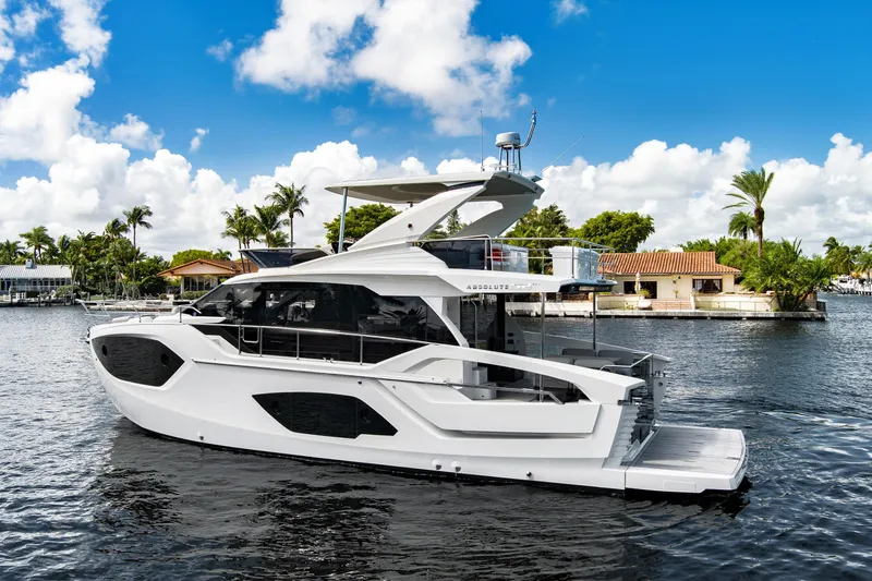 Joan's Rondevous Yacht Photos Pics Luxury 2025 Absolute 52 FLY yacht on serene water, under a bright blue sky.