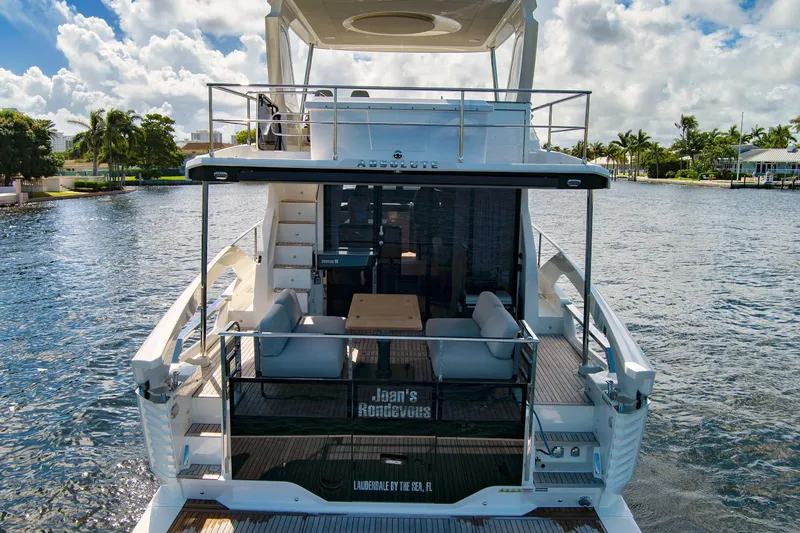 Joan's Rondevous Yacht Photos Pics 2025 Absolute 52 FLY yacht on water, featuring spacious deck and luxurious seating.
