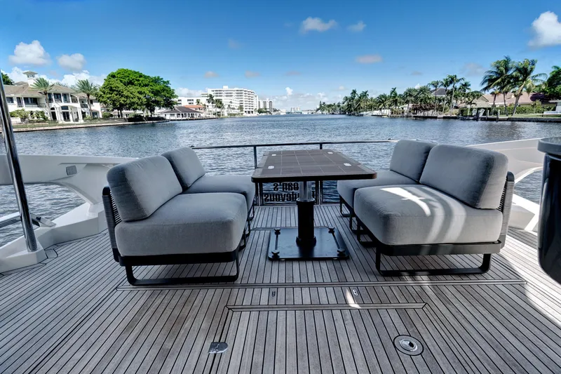 Joan's Rondevous Yacht Photos Pics Luxurious 2025 Absolute 52 FLY yacht deck with elegant seating and scenic waterfront view.